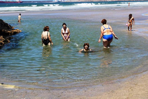 Clientes dos Espaços de Convívio tomam banho na praia