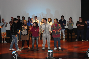 Clientes e técnicos da A2000 atuam no palco de auditório em festa de fim de ano