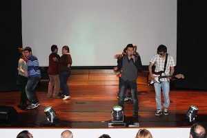 Clientes e técnicos da A2000 atuam no palco de auditório em festa de fim de ano